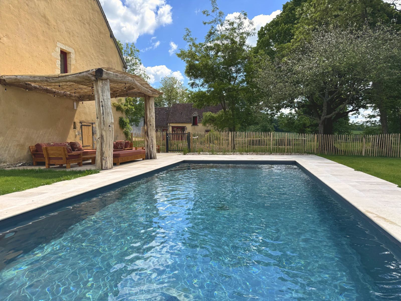 Piscine chauffée à 28 °C et salon d'été couvert, sous les arbres — Maison Oiserie